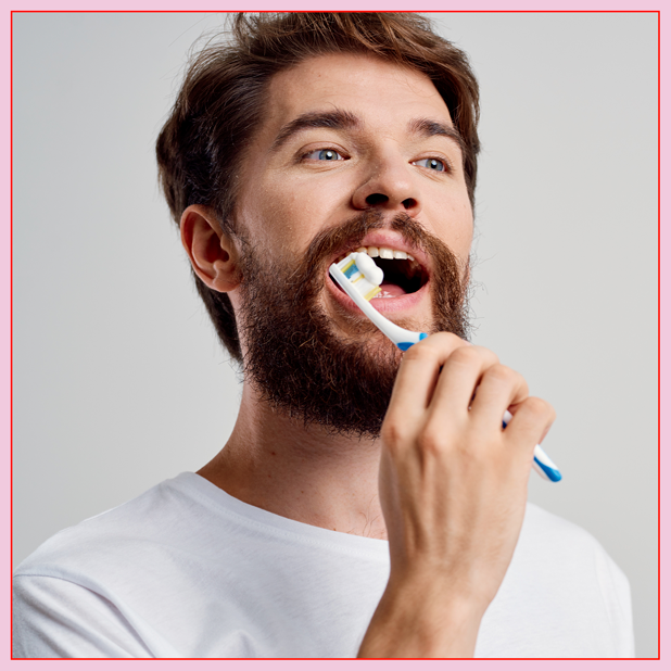 A man brushing his teeth for good dental care.