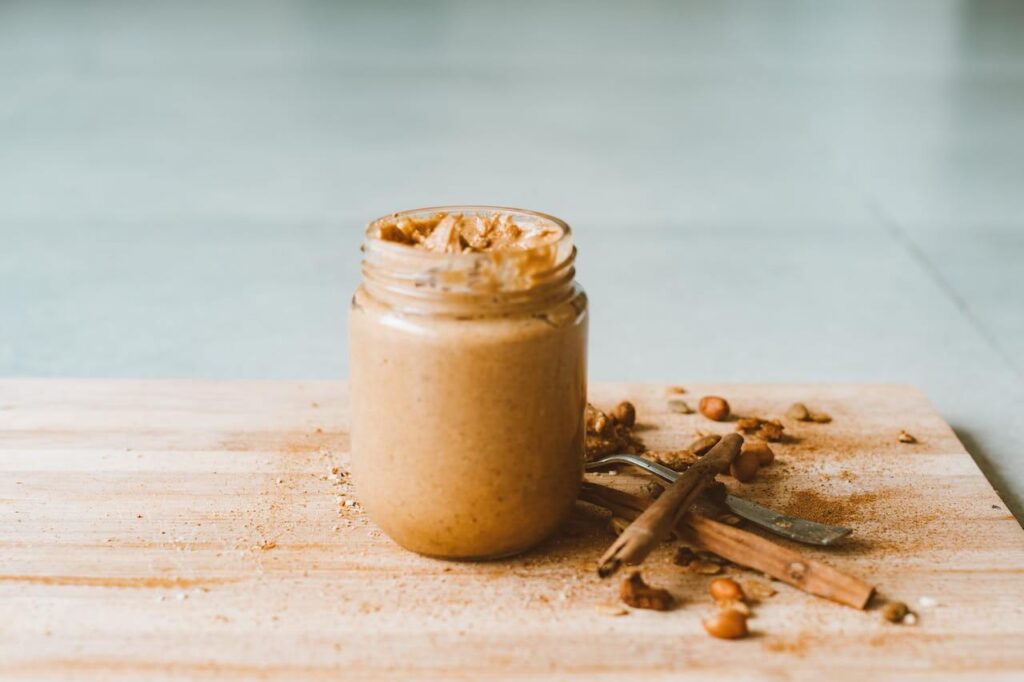 A jar of creamy peanut butter on a tabletop, ready for spreading on your favorite treats