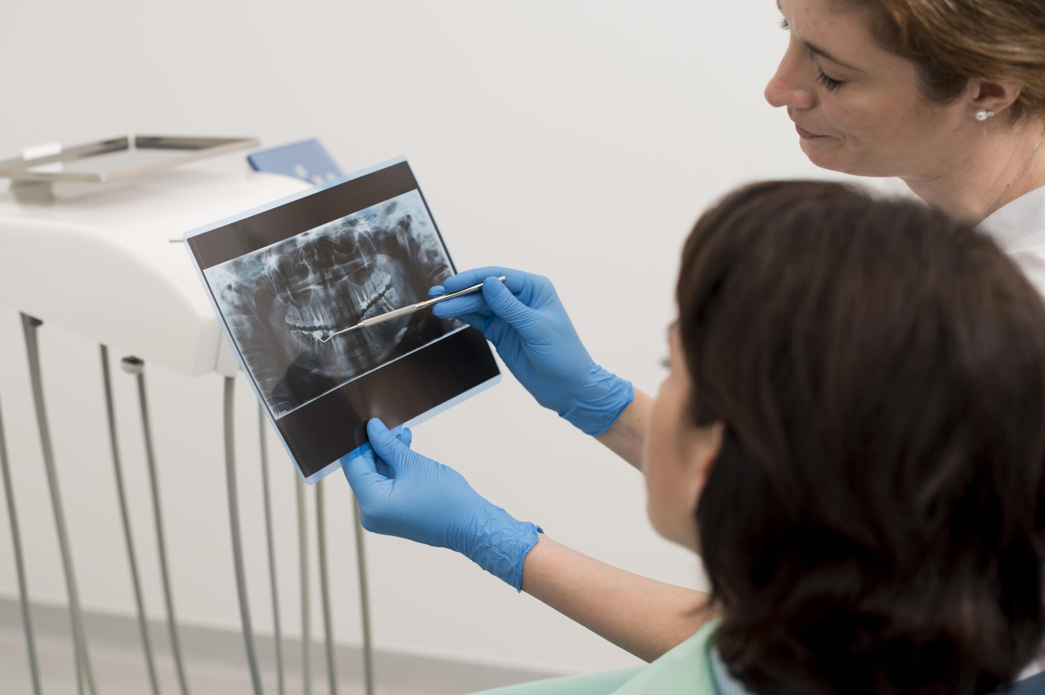 A photograph of a dentist showing a woman her X-ray results during a dental check-up.