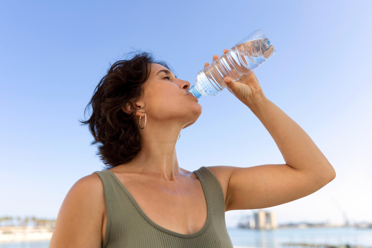 A refreshing photograph featuring a woman gracefully sipping water, promoting oral health and wellness with Trust Dental Care.