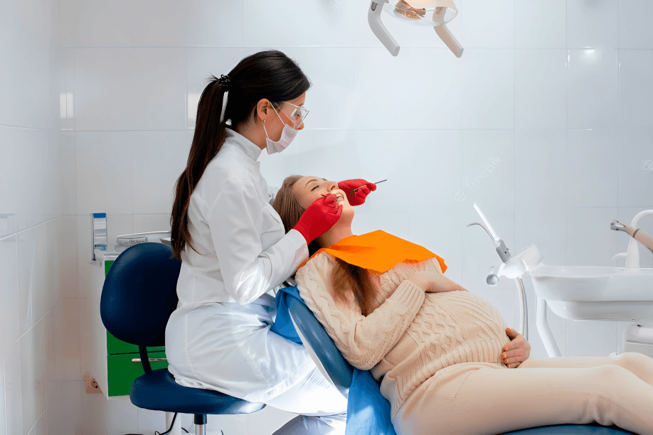 A photograph of a pregnant woman in a dental office.