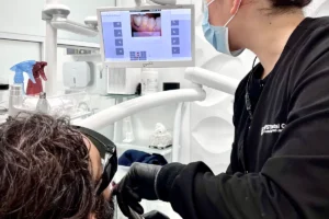 Tijuana Dentist for Dental Implants & Full Mouth Restoration in Mexico 14 dentist working with young patient, scanning in front of screen