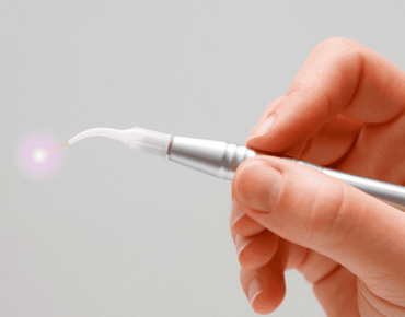 a hand holding a laser dental with white backgrounn